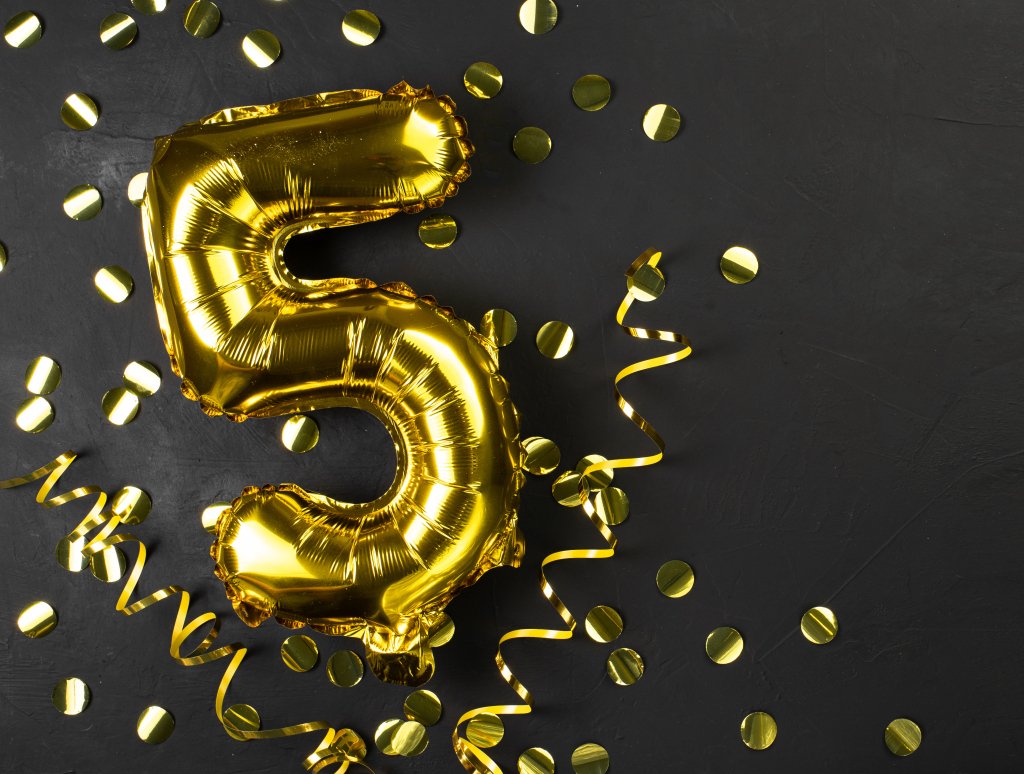 gold foil balloon number five or fifth.Birthday greeting card with inscription 5.Black concrete background. Celebrating the anniversary. Banner. copy space